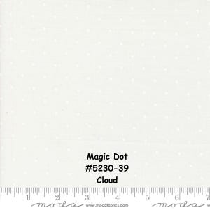 May include: A white fabric featuring a repeating pattern of small, light-coloured dots. The text "Magic Dot #5230-39 Cloud" is printed on the fabric. A ruler at the bottom shows measurements in inches, indicating a scale of 7 inches across.