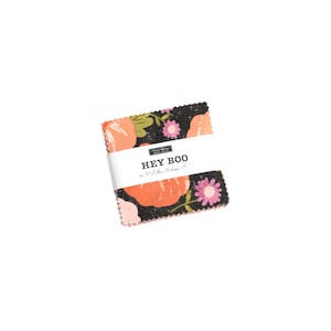 May include: A bundle of fabric squares with a floral design of orange pumpkins and pink flowers on a black backdrop. The fabric is wrapped with a white band that reads "HEY BOO" in black text.