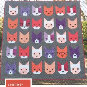 May include: A gray quilt featuring a repeating pattern of cat faces in various colors, including orange, pink, purple, and white. Some cats have glasses. The quilt measures 66 inches by 66 inches. The text "THE KITTENS" is at the top.