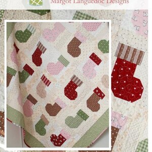 May include: A quilt pattern featuring a variety of colorful stockings with different patterns. The quilt is made up of squares and rectangles, and the stockings are arranged in a random pattern. The quilt is called "Stocking Stuffers" and is available from The Pattern Basket, Margot Languedoc Designs.