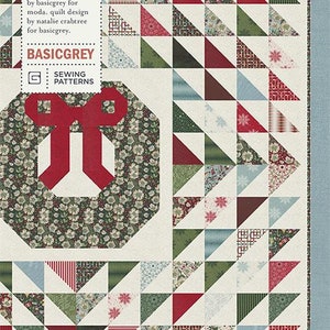 May include: A quilt pattern featuring a red and green wreath with a bow. The pattern is called "Tis the Season" and is by BasicGrey for Moda. The pattern is for a quilt design by Natalie Crabtree.