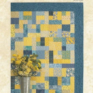 May include: A quilt pattern featuring a patchwork design of yellow and blue squares, with the title "Yellow Brick Road" printed below.