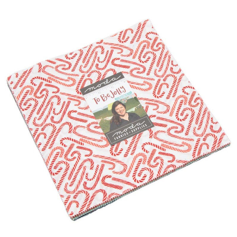 Może przedstawiać: Stos kwadratowych tkanin z białym tłem i wzorem czerwono-białych cukierk&oacute;w w kształcie laski. Kwadraty tkanin są oznaczone "To Be Jolly" i "Moda Fabrics - Supplies".