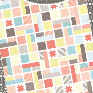 May include: A quilt pattern called "Poppyseed" from the Coriander Quilts collection by Corey Yoder. The quilt features a patchwork design with squares of various colours and patterns, including red, yellow, blue, and brown. The quilt is surrounded by a border of white polka dots on a grey background.