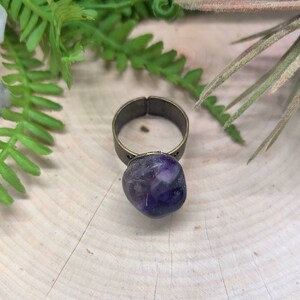May include: A purple amethyst stone ring with a brass band.