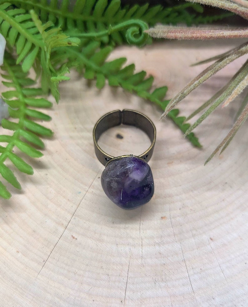 May include: A purple amethyst stone ring with a brass band.