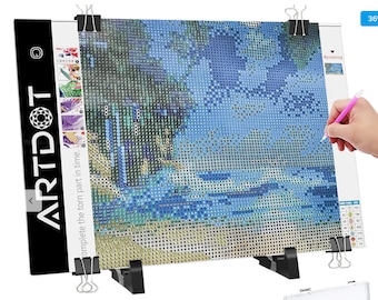 May include: A black stand with two clips holds a diamond painting canvas with a blue and green landscape. The canvas is partially covered with diamonds and a pink pen is being used to place the diamonds. The stand has the words "ARTDOT" and "complete the torn part in time" printed on it.