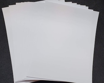 Może przedstawiać: Stos białego papieru do kartonu.
