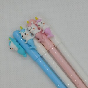 May include: Four unicorn-shaped pens with blue, pink, and white barrels. The unicorn heads are made of plastic and have a 3D effect.