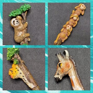 May include: A set of five animal figurines, each with a different design. The figurines are made of a brown, tan, and white material and are attached to a stick. The figurines include a sloth, a monkey, a giraffe, a cheetah, and a monkey.