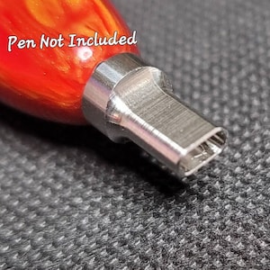 May include: Close-up of a red and yellow wooden pen with a silver metal tip. The tip is shaped like a small rectangle with rounded corners. The text "Pen Not Included" is visible in the image.