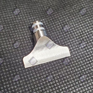 May include: A silver metal nozzle with a white plastic ring around the top. The nozzle has a flat, wide opening.