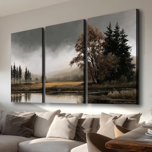 Peut inclure: Un ensemble de trois panneaux de toile murale représentant un paysage avec un lac calme, des champs dorés et des conifères sombres sous un ciel nuageux et couvert. La scène présente des tons sourds de brun, gris et vert foncé.