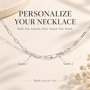 Può includere: Una collana a catena con maglie rettangolari color argento e due targhette metalliche incise con i nomi Merica e John. Il testo PERSONALIZE YOUR NECKLACE, Add the names that mean the most, NAME 1, NAME 2 e Made Just for You è visibile.
