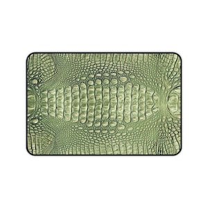 May include: A rectangular mat featuring a detailed, repeating light green crocodile skin texture pattern. The surface displays a realistic embossed scale design with varying sizes of rounded, raised shapes across the entire rectangular area.