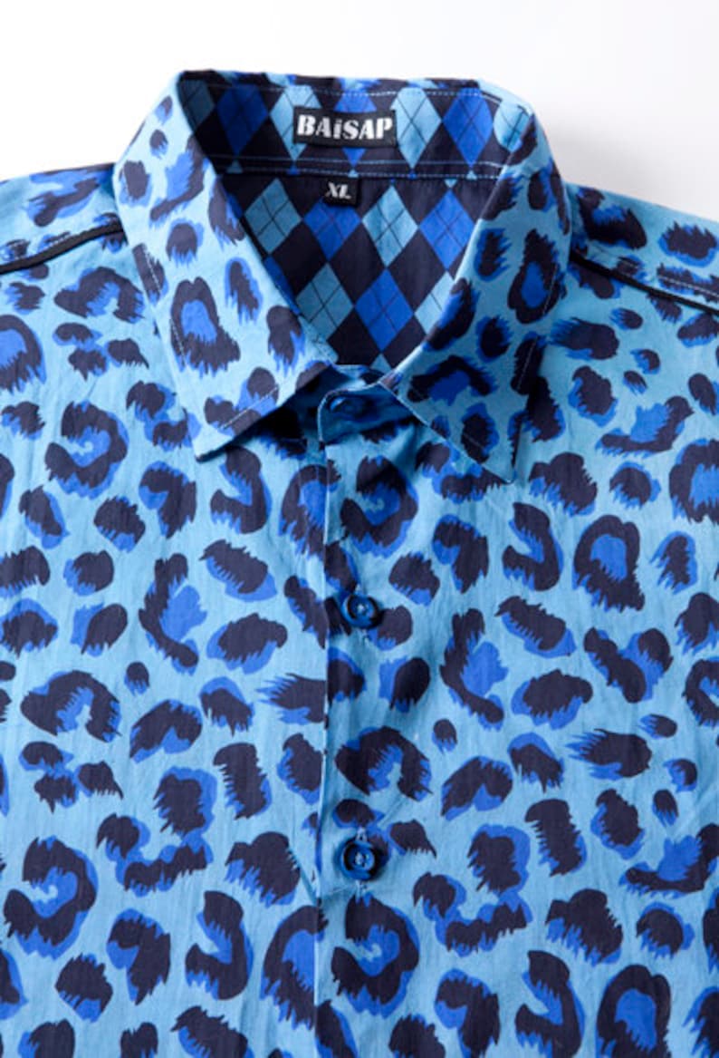 Puede incluir: Una camisa de botones azul y negro con estampado y cuello. El cuello tiene un estampado a cuadros contrastante azul y negro. La camisa tiene el texto "BAISAP" y "XL" en el cuello.