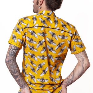 May include: A yellow short-sleeved shirt with a black and white beetle pattern.