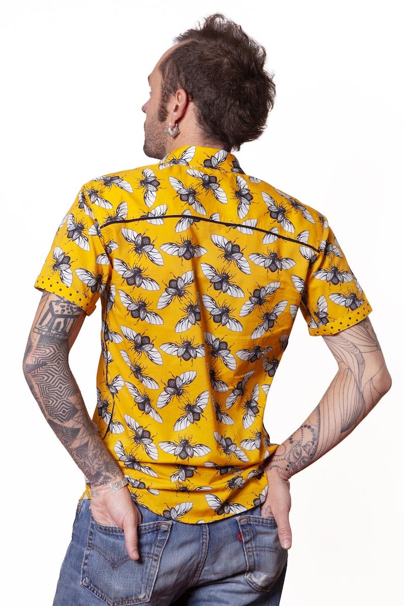 May include: A yellow short-sleeved shirt with a black and white beetle pattern.