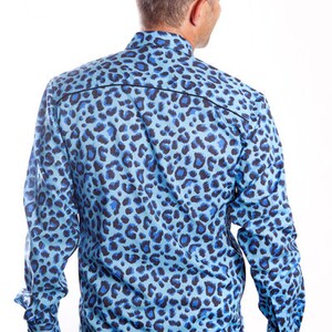 Puede incluir: Una camisa azul de manga larga con estampado de leopardo.