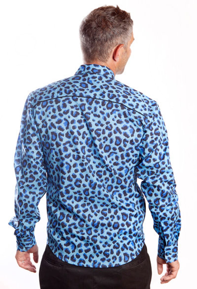 Puede incluir: Una camisa azul de manga larga con estampado de leopardo.