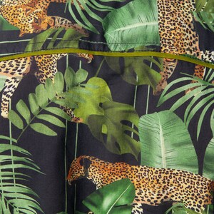 May include: A black fabric with a green and brown jungle print featuring leopards and tropical leaves.