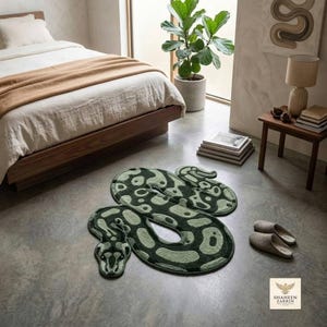 Peut inclure: Un tapis en forme de serpent avec un motif tacheté vert foncé et vert clair. Le tapis est conçu dans une position enroulée avec une forme de tête distincte et des segments de corps arrondis, posé à plat sur un sol lisse dans une chambre.