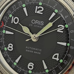 Puede incluir: Un reloj de pulsera automático Oris con esfera gris oscuro, centro texturizado, números arábigos plateados y un anillo de fecha numerado del 1 al 31. La esfera muestra el texto Oris, 25 Jewels, Automatic, Swiss Made y agujas luminosas.