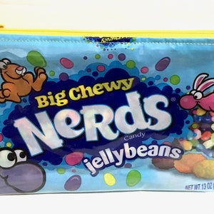 May include: A blue zippered pouch with a Nerds Big Chewy Jellybeans design. The pouch features two cartoon bunnies and colorful jellybeans.