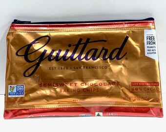 May include: A gold and red pouch of Guittard semisweet chocolate baking chips. The pouch has a zipper closure and features the Guittard logo, the words "Semisweet Chocolate Baking Chips", and "100% Real Chocolate 46% Cacao". It is labeled "Free From Peanuts, Tree Nuts & Gluten".