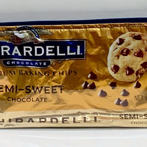 May include: A gold-colored zippered pouch made from a Ghirardelli chocolate chip bag. The pouch features the Ghirardelli logo, the words "Premium Baking Chips," and "Semi-Sweet Chocolate." The image also shows chocolate chip cookies and loose chocolate chips.
