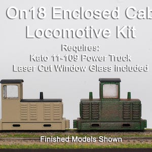 May include: Two model train locomotives. One is tan, the other is green. The text "On18 Enclosed Cab Locomotive Kit" is at the top. The text "Finished Models Shown" is at the bottom.