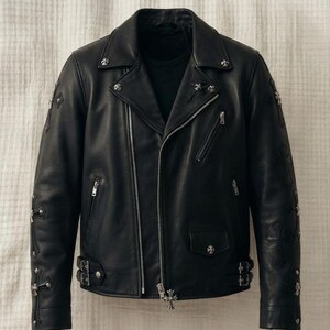 Könnte beinhalten: Eine schwarze Motorradjacke aus Leder mit silberfarbenen, kreuzförmigen Metallbeschlägen, mehreren Reißverschlusstaschen, einem fallenden Revers und verstellbaren Seitenschnallen. Ärmel und Brust sind mit dekorativen silbernen Kreuzen verziert.