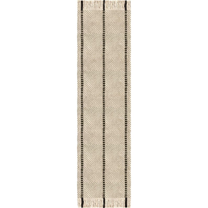 May include: A rectangular table runner featuring a woven beige and cream textured pattern with three vertical black stripes running the length of the fabric. The top and bottom edges are finished with short, cream-colored fringe.