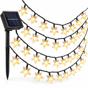 May include: A string of solar-powered LED lights featuring translucent star-shaped covers that emit a warm yellow glow. The lights are connected by a black wire and include a black solar panel mounted on a stake for outdoor installation.