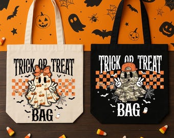 May include: Two tote bags, one cream and one black, each featuring the text "TRICK OR TREAT BAG" and a ghost character. The cream bag shows a ghost with a bow and cherry print, while the black bag shows a ghost in a cap with a camouflage pattern.