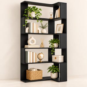 May include: A tall, black, L-shaped bookcase with five levels of open shelving. The shelves are decorated with various items including green potted plants, a collection of books, a small hourglass, a framed print, a globe, and a woven basket.