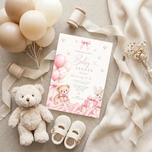 May include: A rectangular baby shower invitation card featuring a watercolor illustration of a teddy bear, pink balloons, and gift boxes. The text reads: Please join us for a baby shower honoring mummy to be, Saturday 12th April at 2 o'clock, the garden room, 123 any street, anytown, ab12 3cd, RSVP 0123456789.
