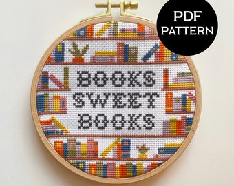 May include: A cross-stitch pattern featuring a white background with colorful books on shelves and the text "Books Sweet Books". The pattern is framed in a wooden hoop.