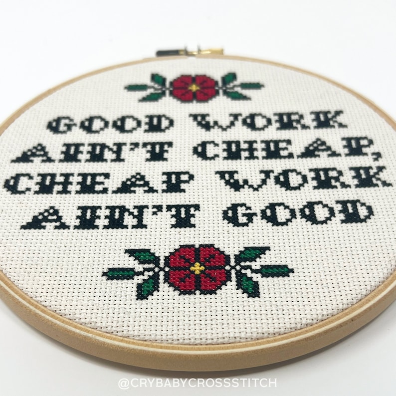 May include: A white embroidery hoop with a cross-stitch design that reads "Good work ain't cheap, cheap work ain't good". The design is in black thread with red and green accents.