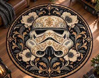 Op de afbeelding: Een rond vloerkleed met een crèmekleurige Stormtrooper-helm in het midden, versierd met ingewikkelde gouden en zwarte filigraanpatronen, omringd door een symmetrische opstelling van crèmekleurige bloemen en donker gebladerte op een zwarte achtergrond.