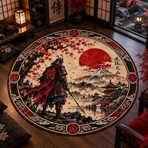 Pode incluir: Um tapete circular com um samurai em armadura tradicional perante uma paisagem com um grande sol vermelho, o monte Fuji, um pagode e uma ponte. O design inclui ramos de cerejeira em flor e caracteres kanji japoneses em preto.