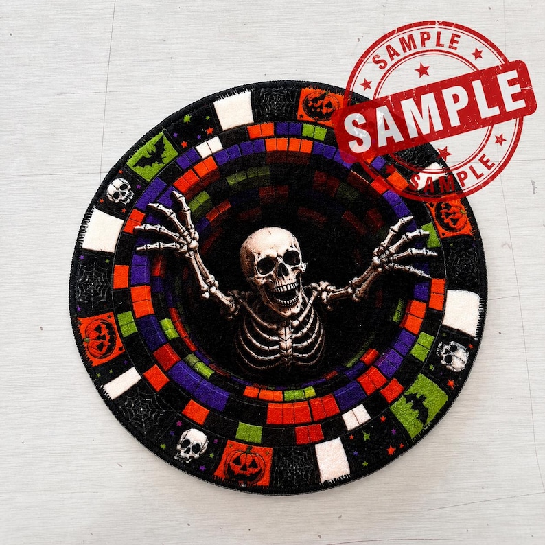 May include: A circular rug featuring a central skeleton with raised arms emerging from a black void. The border consists of a colorful mosaic-style pattern of squares in orange, purple, green, and white, interspersed with icons of skulls, bats, and pumpkins.