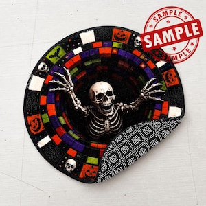 May include: A round rug featuring a 3D-style tunnel design with a central skeleton reaching upward. The border displays colorful squares, pumpkins, bats, and skulls. A red circular stamp with the text SAMPLE is visible in the upper right corner.