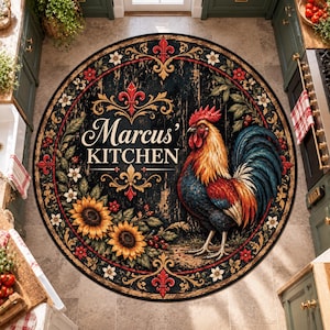 Op de afbeelding: Een rond tapijt met een donkere houtnerfachtergrond, een kleurrijke haan en twee zonnebloemen. De tekst 'Marcus' KITCHEN' is in het wit gedrukt, gecentreerd boven de haan. De rand is versierd met rode fleur-de-lis en kleine bloemen.
