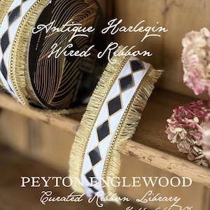 May include: A white wired ribbon featuring a repeating black diamond pattern and metallic gold fringe trim along both edges. The ribbon is displayed on a spool and unrolled, with text overlay reading Antique Harlequin Wired Ribbon and PEYTON ENGLEWOOD.