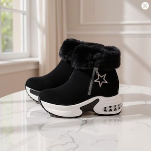 May include: Black ankle boots with a thick white platform sole, a black faux fur collar, and a silver star-shaped zipper pull. The boots feature a side zipper closure and a textured black and white pattern on the heel of the platform sole.