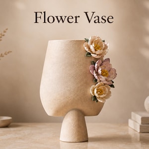 Könnte beinhalten: Eine beige, texturierte Blumenvase mit Standfuß, die auf der rechten Seite mit drei skulpturalen Blüten in Creme-, Rosa- und Lavendeltönen verziert ist. Der Text "Flower Vase" ist in Dunkelbraun über dem Objekt abgedruckt.