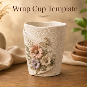 May include: A cream-colored ceramic cup featuring a textured floral pattern and the text Wrap Cup Template. The cup is decorated with three-dimensional sculpted flowers in shades of pink, purple, and beige, along with a small butterfly accent.