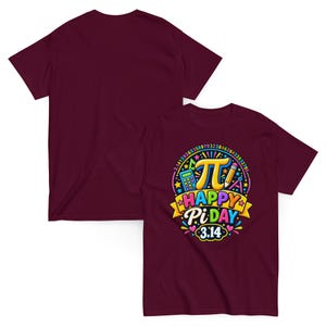 Peut inclure: Un t-shirt à manches courtes bordeaux avec un motif coloré représentant la lettre grecque pi, une calculatrice, un crayon et un compas. Le texte indique "HAPPY PI DAY" et "3.14" entouré d'une séquence circulaire de chiffres de pi et d'étoiles.