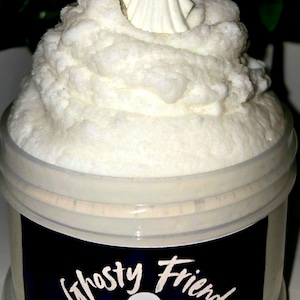 May include: A clear plastic jar filled with white textured slime topped with a small white ghost figurine. The black label on the front features a white ghost illustration and the text Ghosty Friend and Ringo Slime Shop in white lettering.